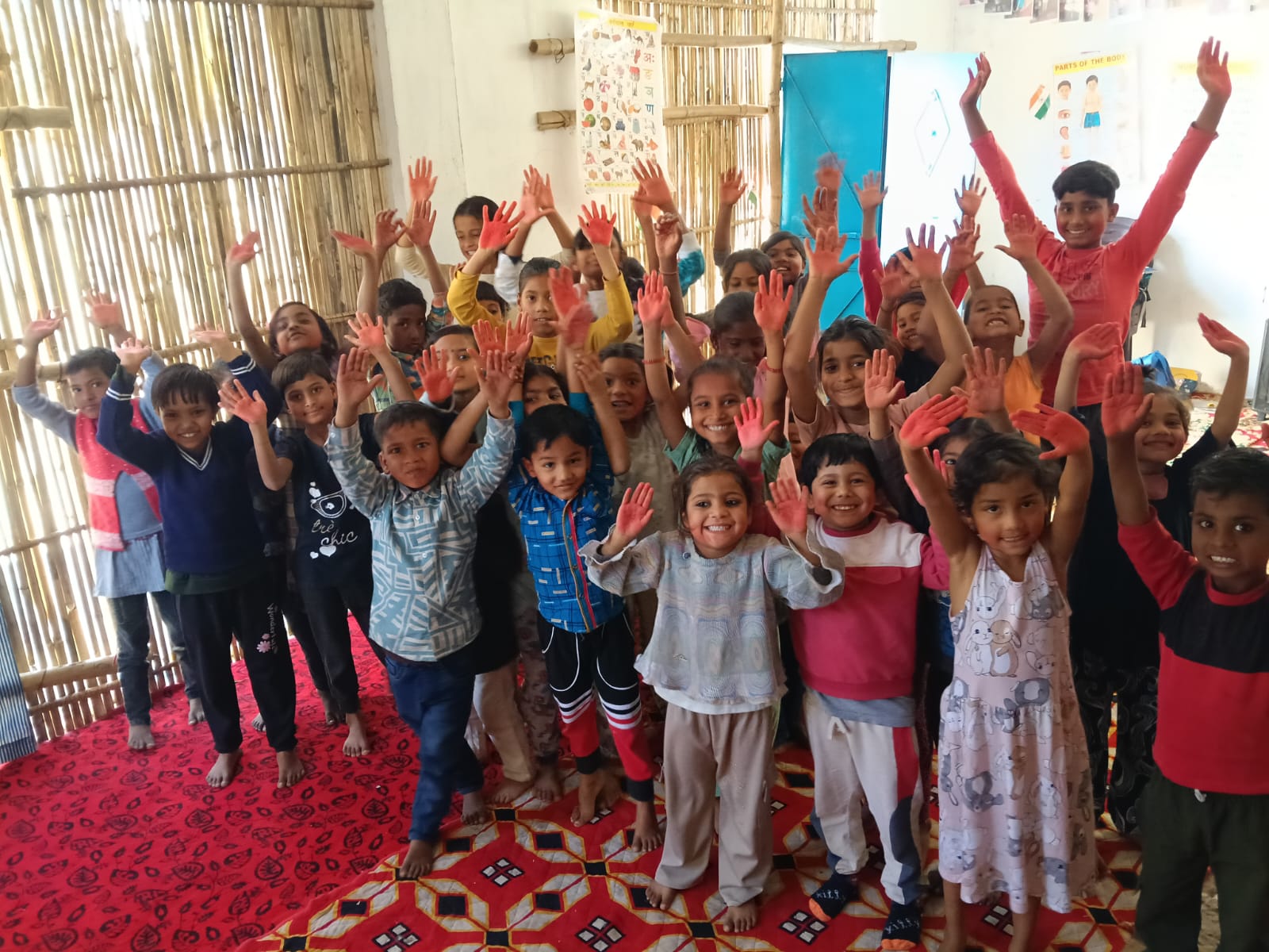 Children at the RHSS DLF Ultima learning centre raising their hands during an activity